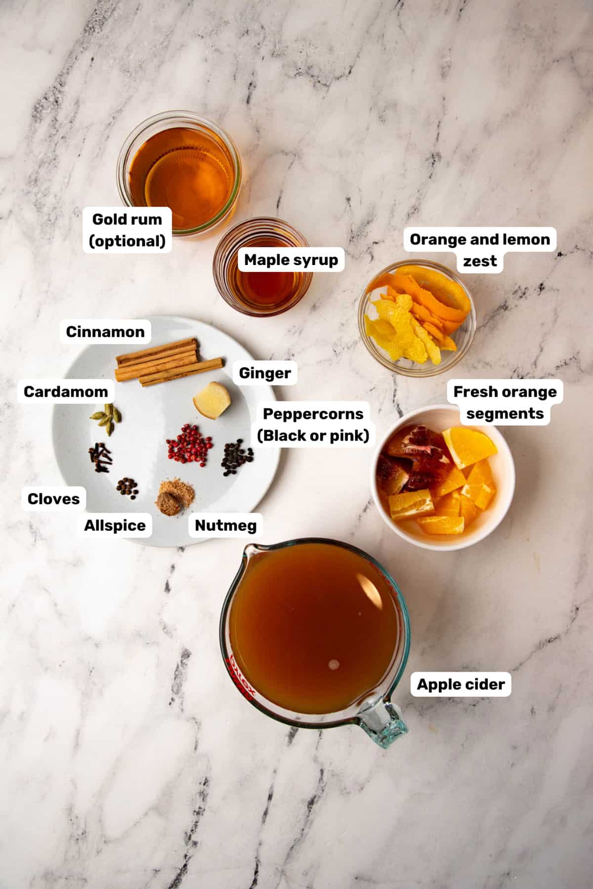 Overhead image of labeled ingredients to make spiced apple cider.