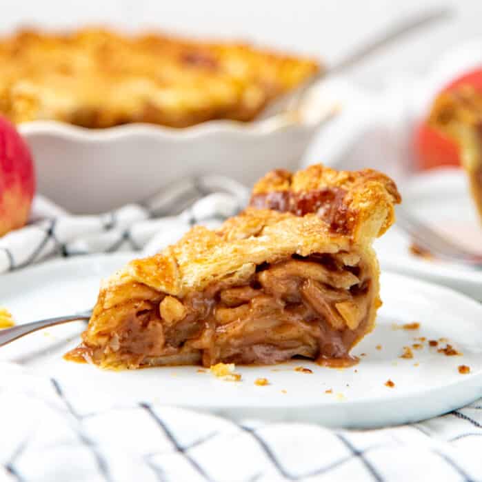 A square image of an apple pie slice on a plate.