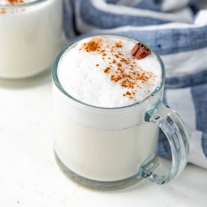 Homemade vanilla steamer topped with cinnamon in a glass mug.