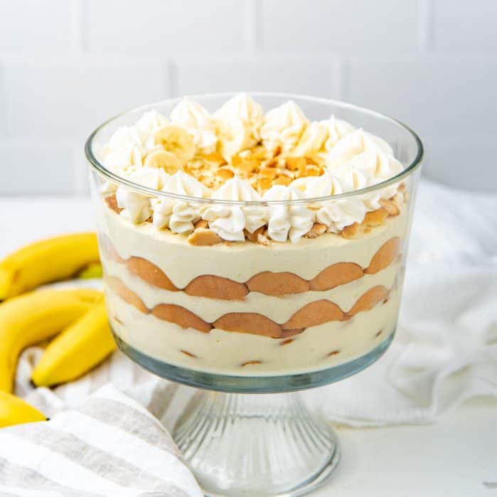 Finished custard pudding in a bowl with bananas in background.