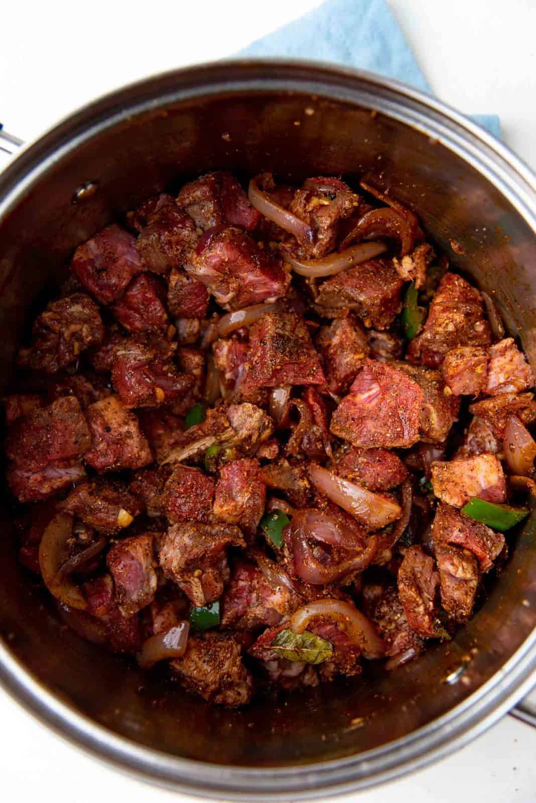 Adding the marinaded beef to be sauteed