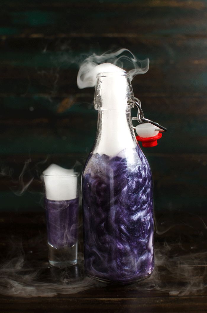 GIF of a bright purple shimmering liqueur bottle with liquid nitrogen-induced smoke coming from the top.