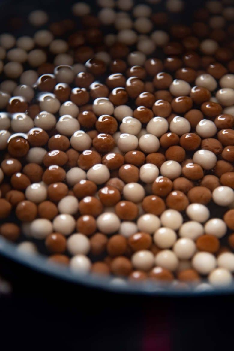 Boba pearls floating in boiling water in a pot