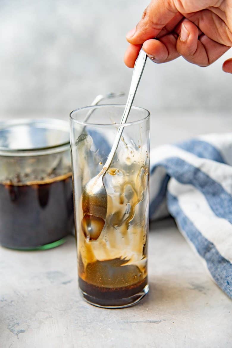 Making brown sugar bubble tea - A spoon dragging the brown sugar syrup along the sides of the glass to create streakes