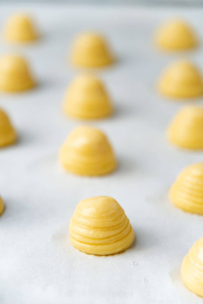Choux pastry piped on a baking sheet