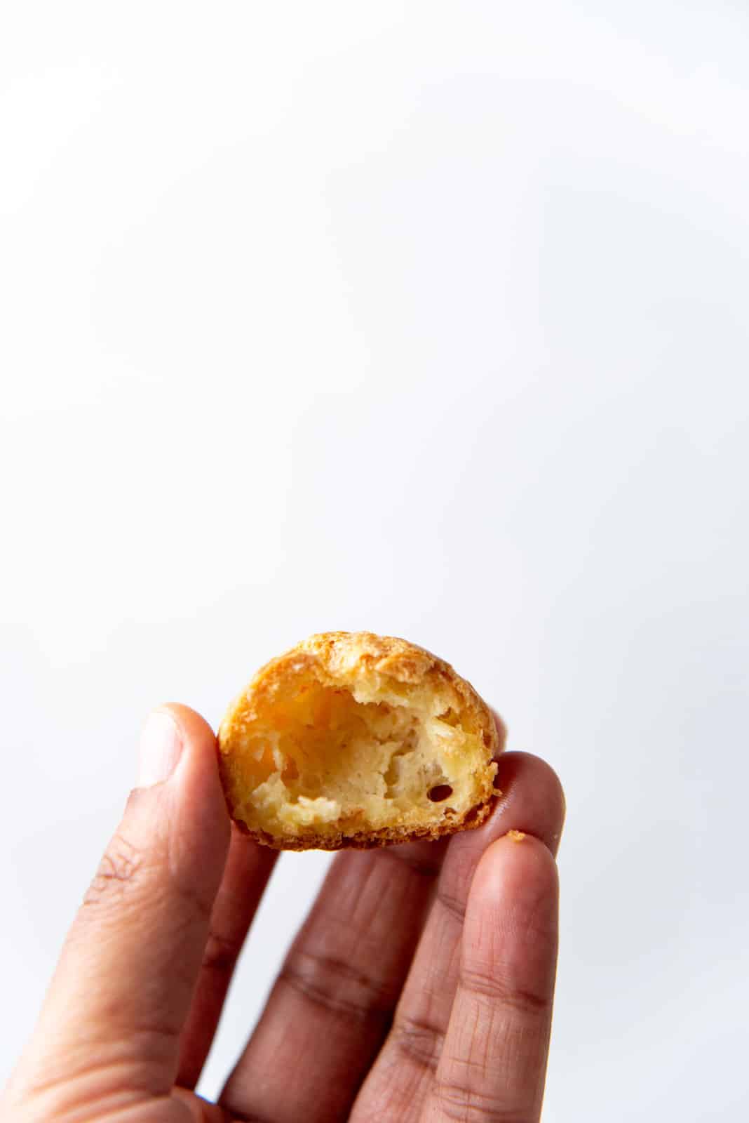 An empty choux puff cut in half to show the center