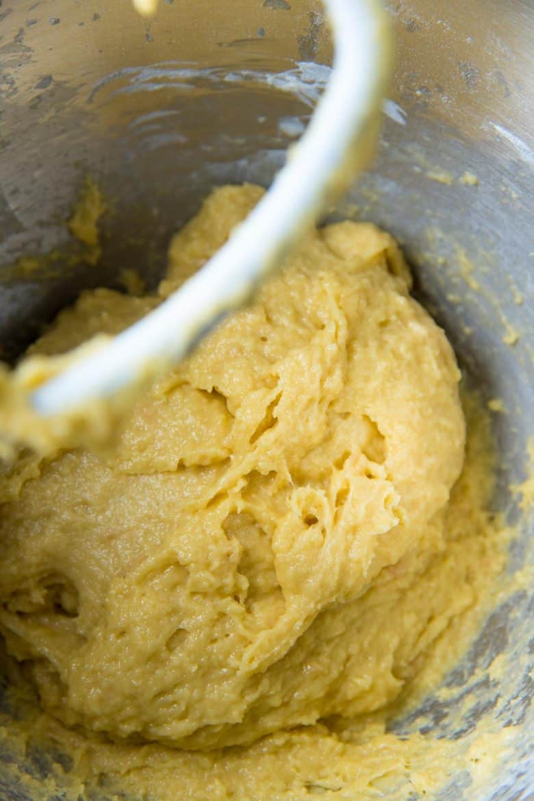 Wet brioche dough kneading in a stand mixer.