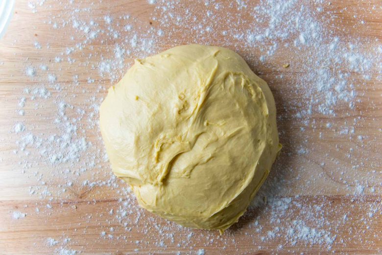 Brioche dough after first proofing on a lightly floured wood work surface.