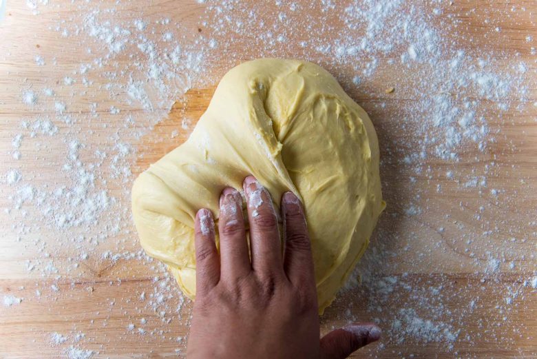 Folding one end of the brioche dough by hand towards the middle.