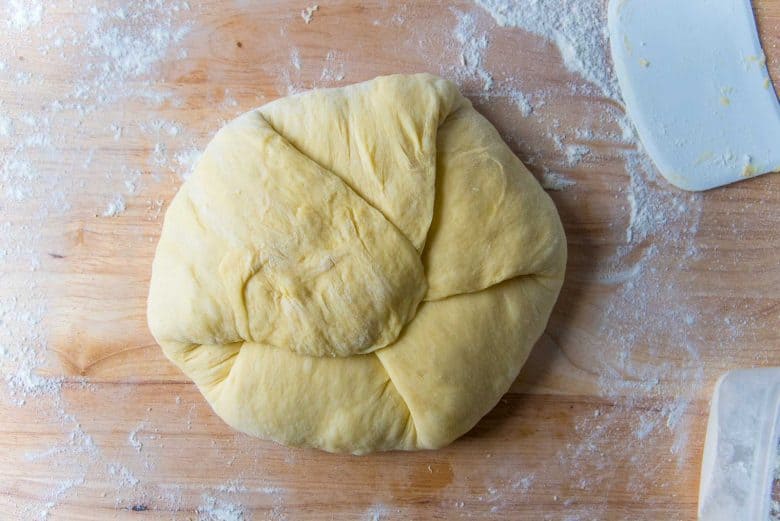 Dough on a lightly floured work surface with the edges folded in towards the middle.
