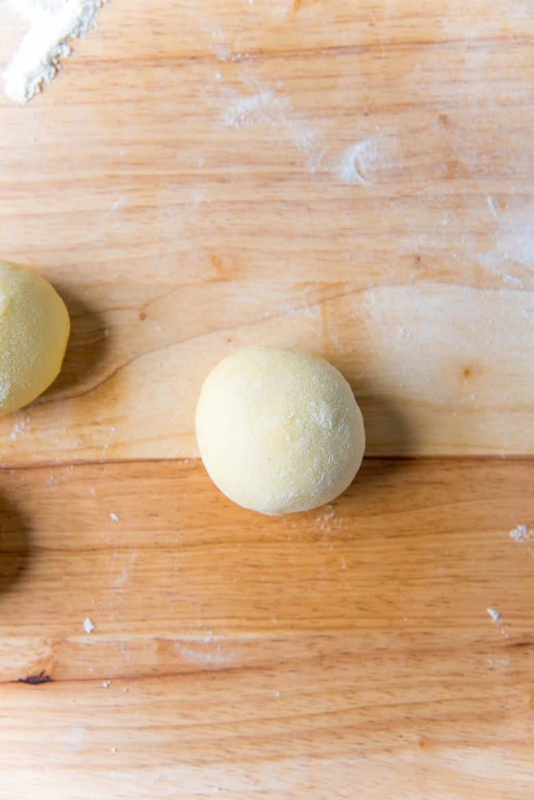 Smooth perfect round dough ball on a work surface.