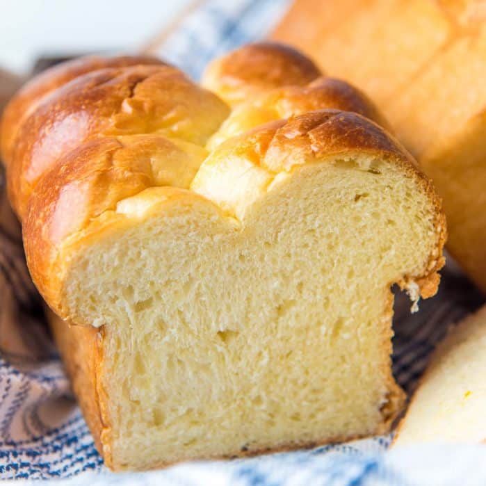 A perfectly baked brioche bread loaf cut in half to show the crumb.