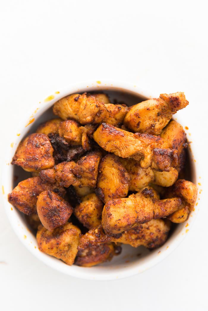 Blackened chicken in a white bowl to make cajun chicken pasta.