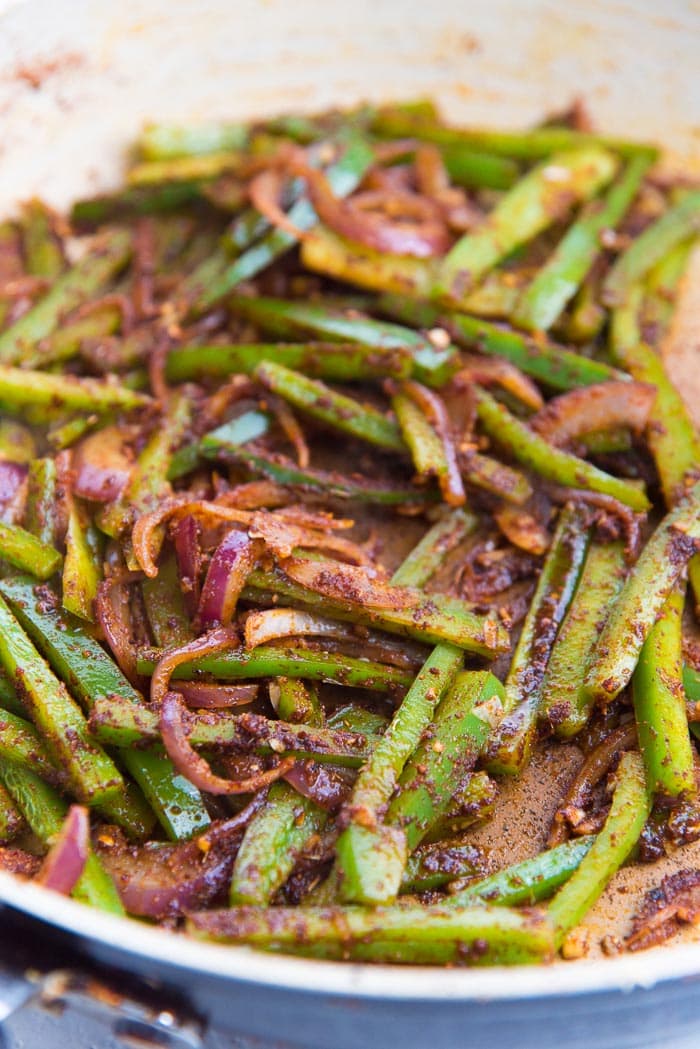 Onions and green pepper pan fried with cajun seasoning in a large saucepan.