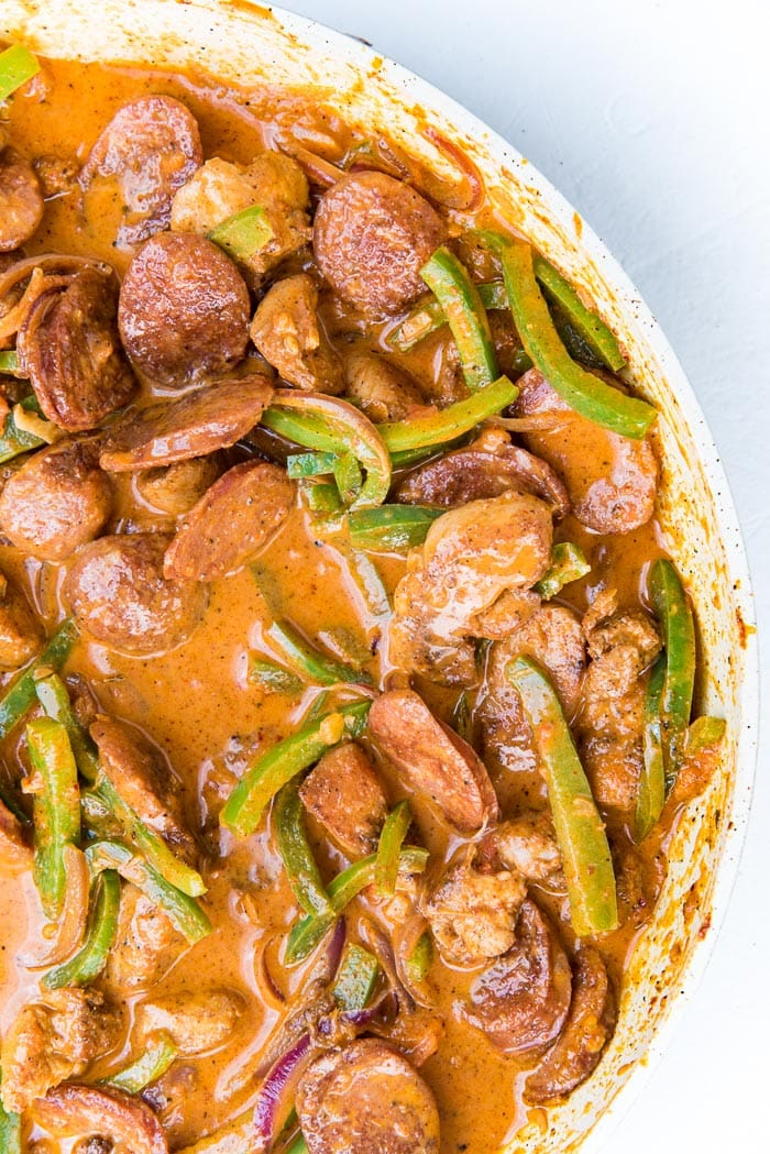 Cajun chicken and sausage pasta sauce mixed in a large pan.