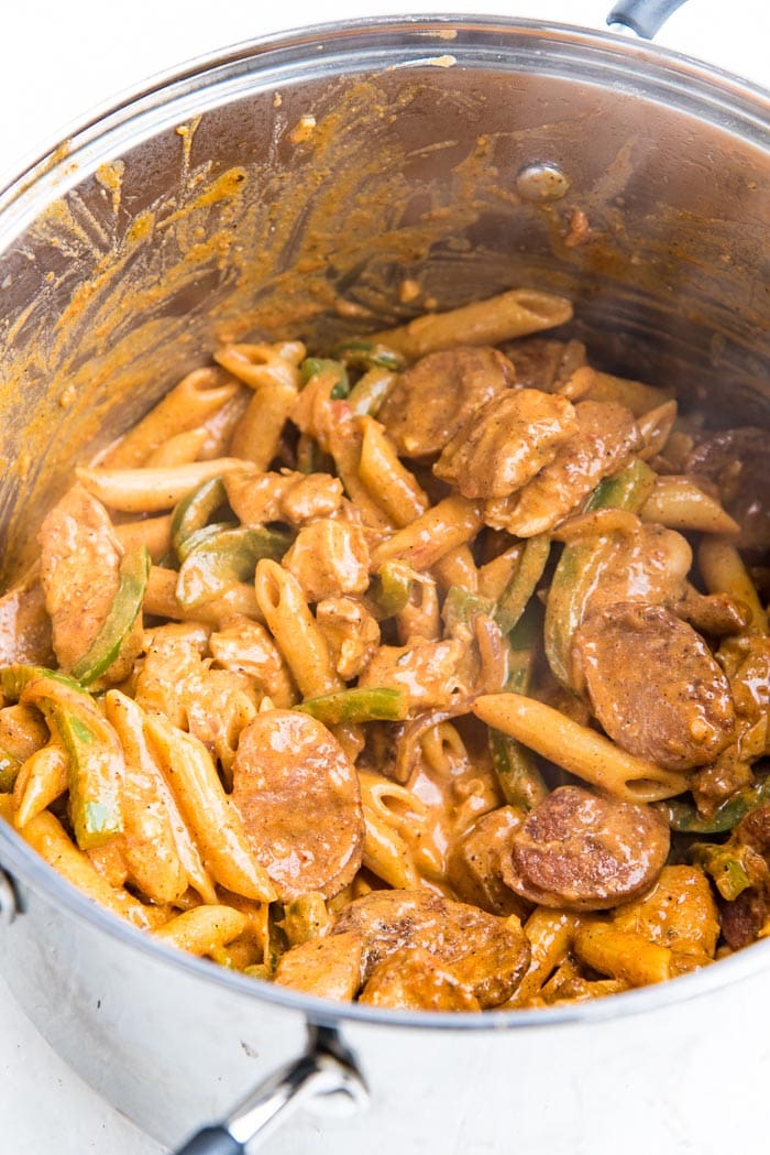 Creamy cajun chicken pasta and andouille sausage in a big pot.