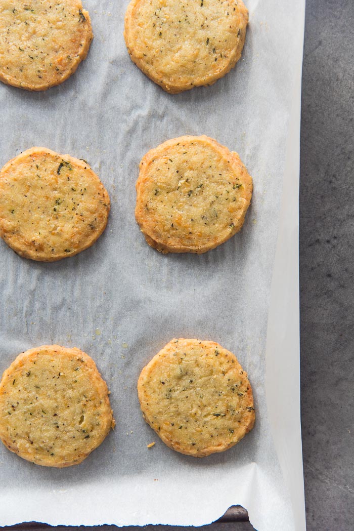Thyme and Cheddar cheese cookies placed on a parchment lined baking tray, after being baked in the oven.