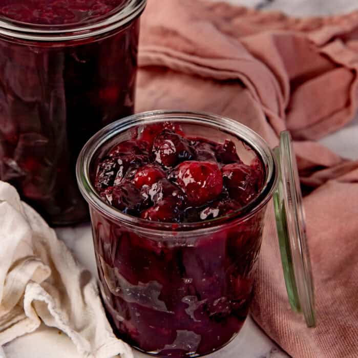 Juicy cherry pie filling in a small glass weck jar.