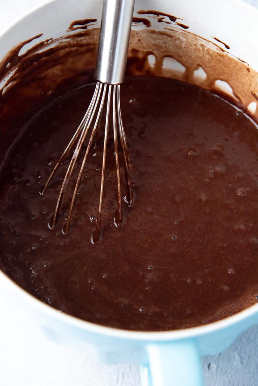 Chocolate cake batter mixed in a bowl and ready to be poured