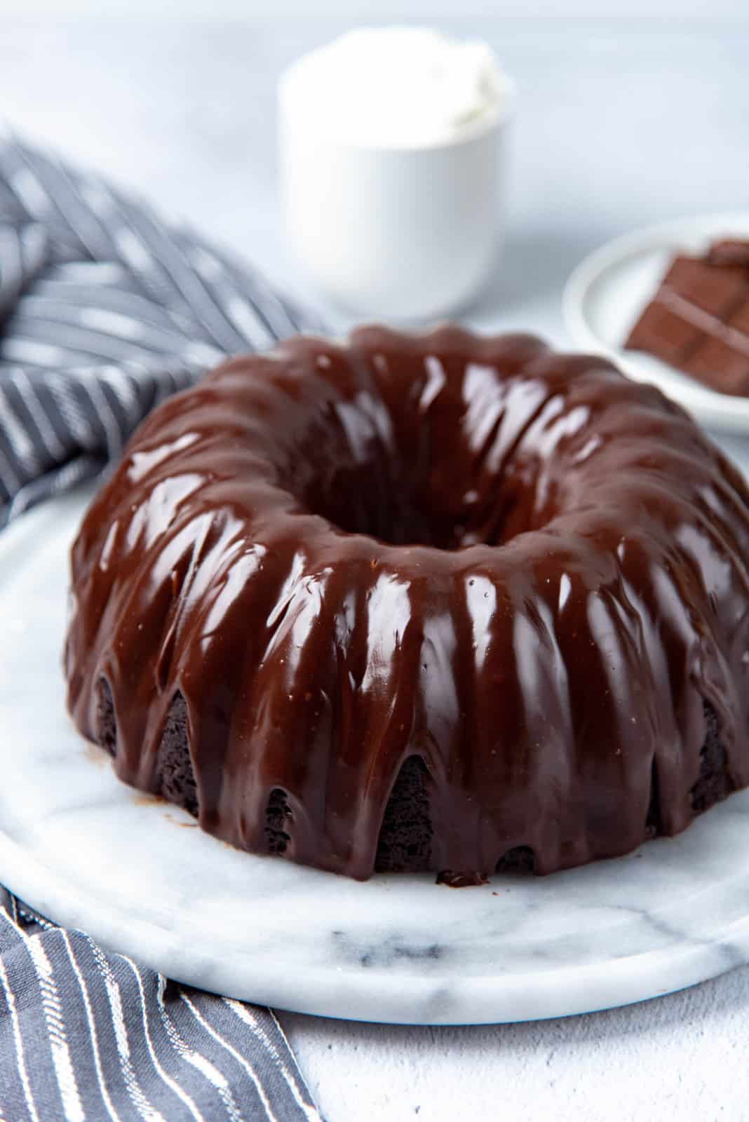The glazed chocolate bundt cake on a serving platter