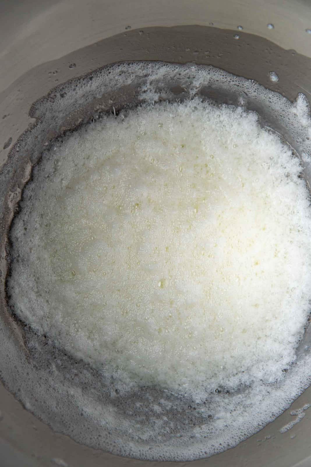 Pasteurized egg white foam in a metal bowl