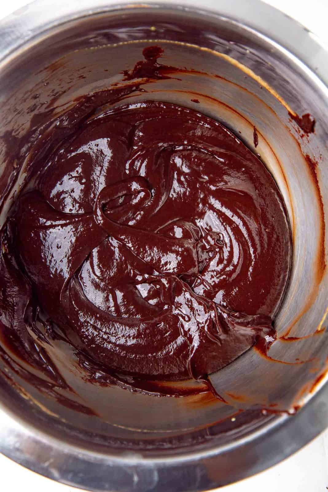 Melted chocolate butter mixture mixed with the egg yolk mixture in a bowl