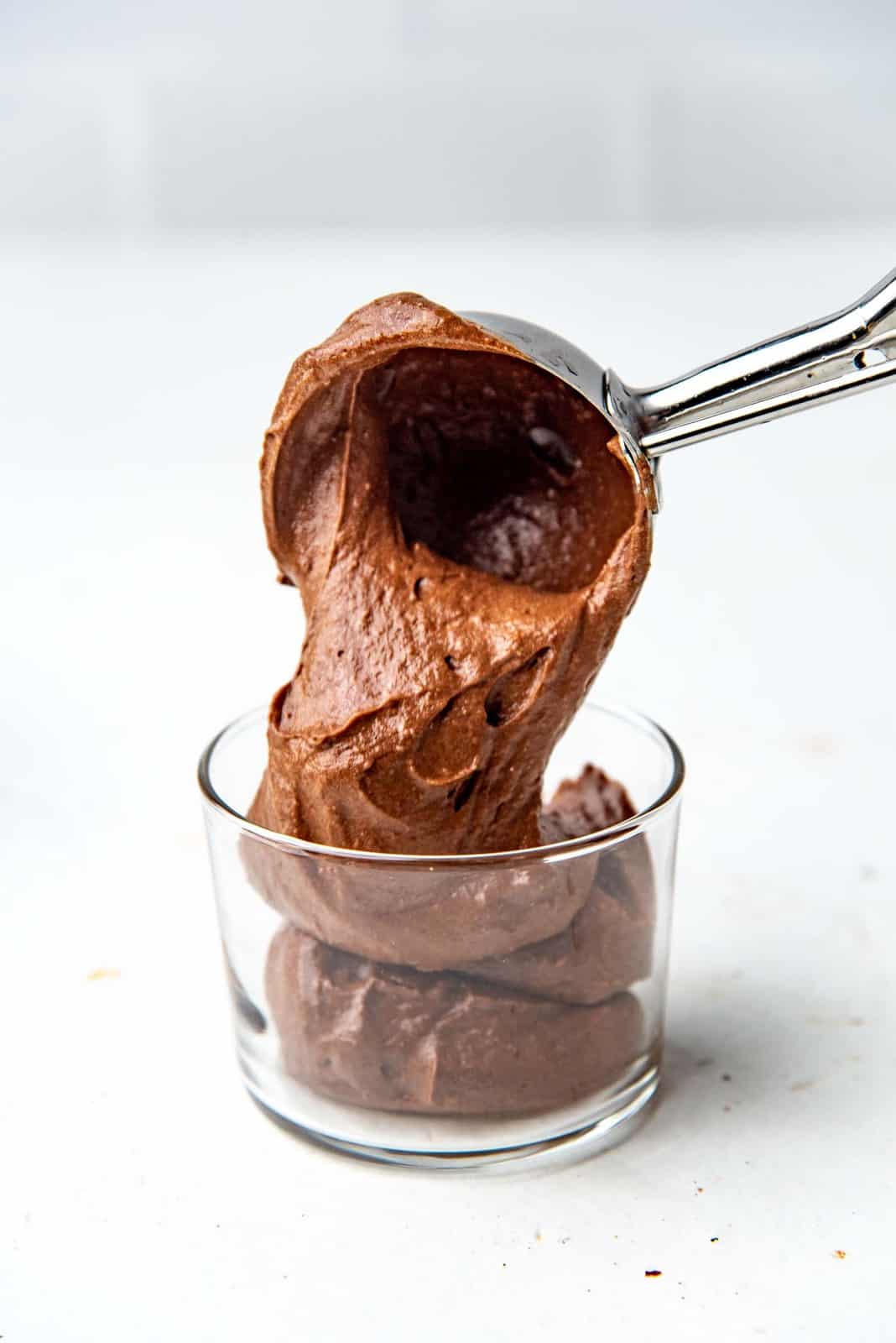 Spooning chocolate mousse into a serving glass