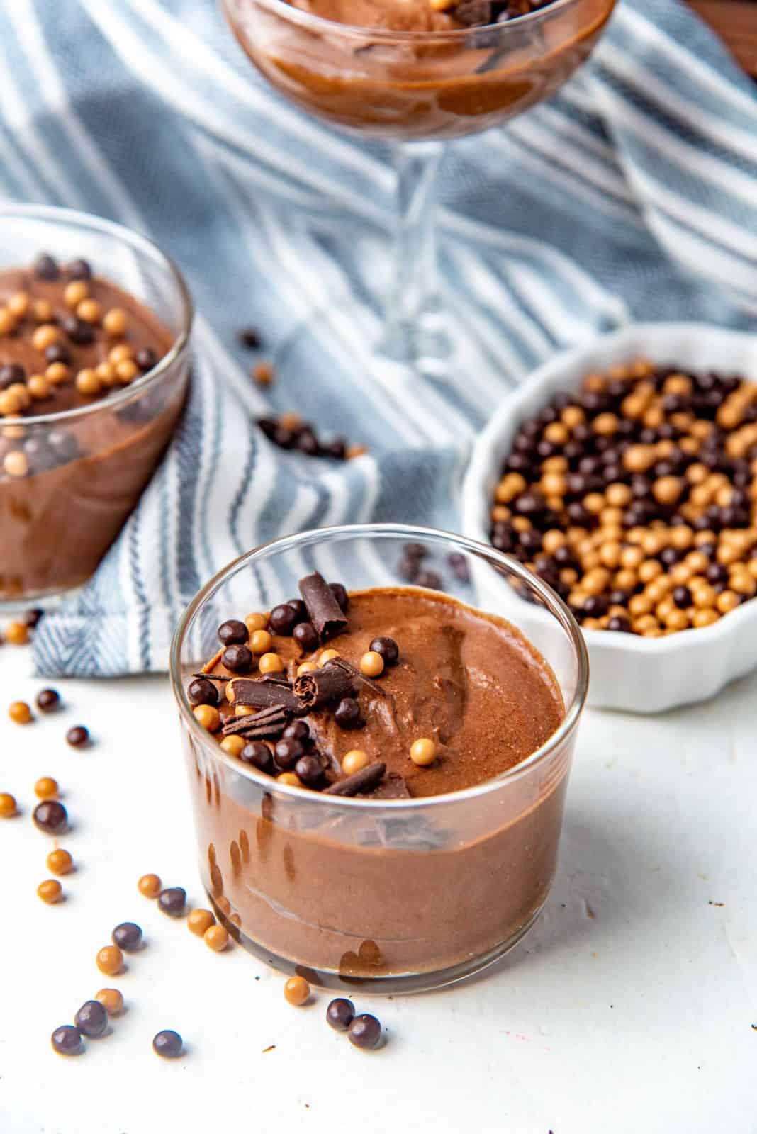 Chocolate mousse served in glasses topped with chocolate decorations