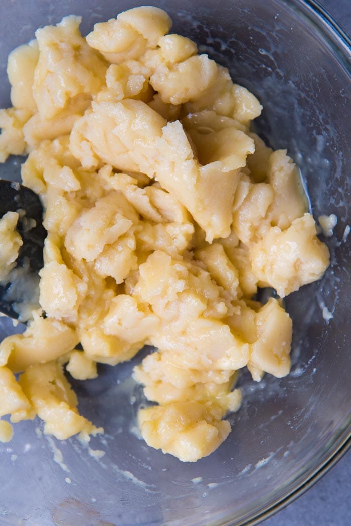 Making perfect choux pastry - Gloopy, slimy looking choux pastry dough when eggs are first added, in a glass bowl.