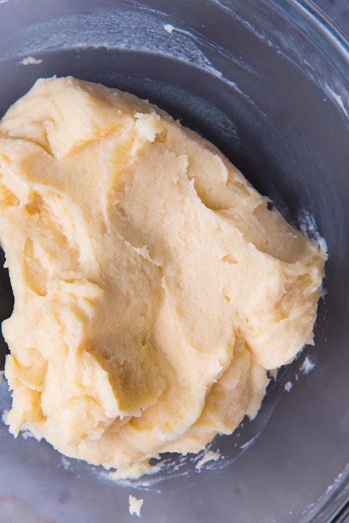 Making perfect choux pastry - Choux pastry dough becoming smoother, after half of the eggs have been added.