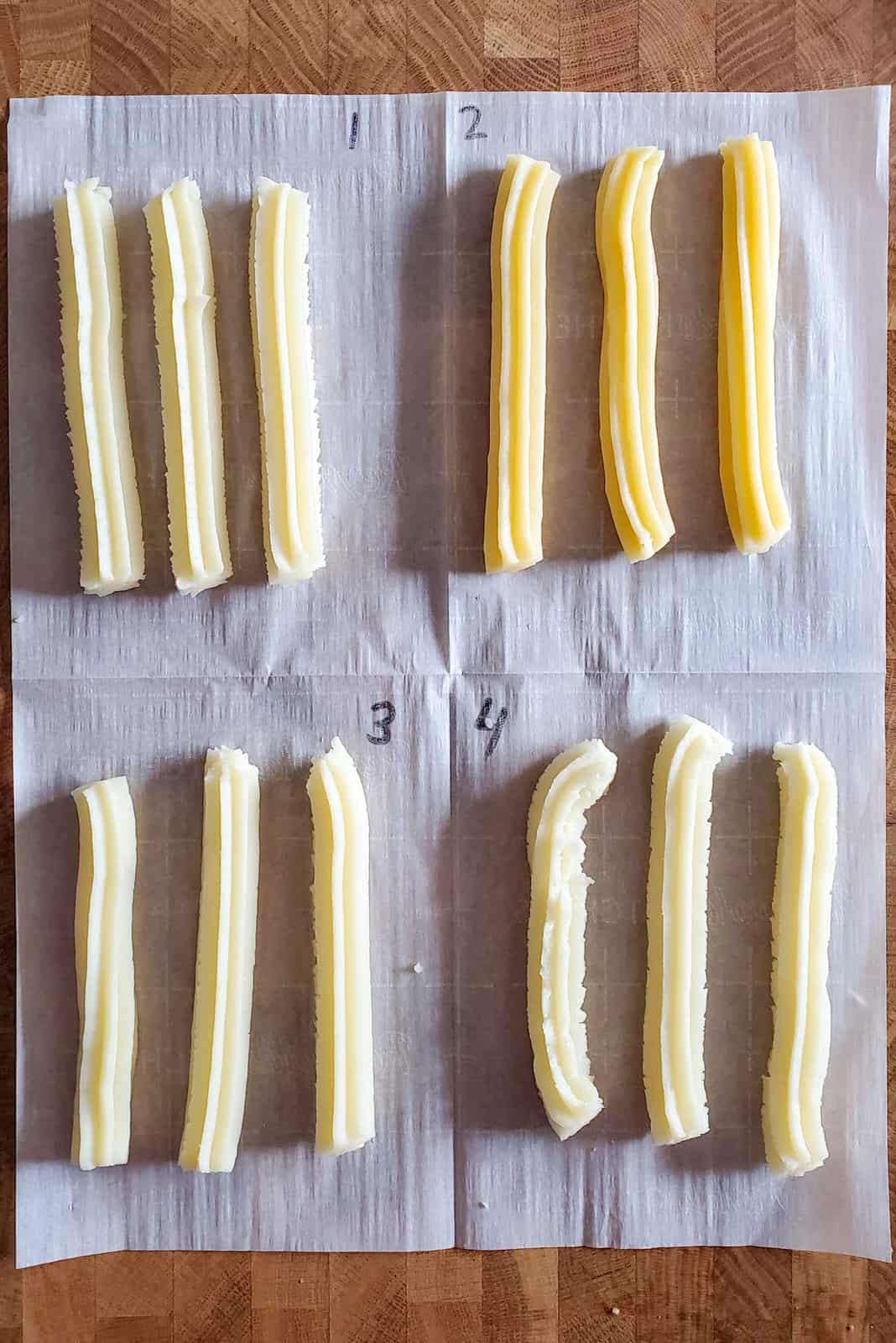 The four different churro doughs from traditional churros to enriched churros, piped on a parchment paper and marked with numbers.