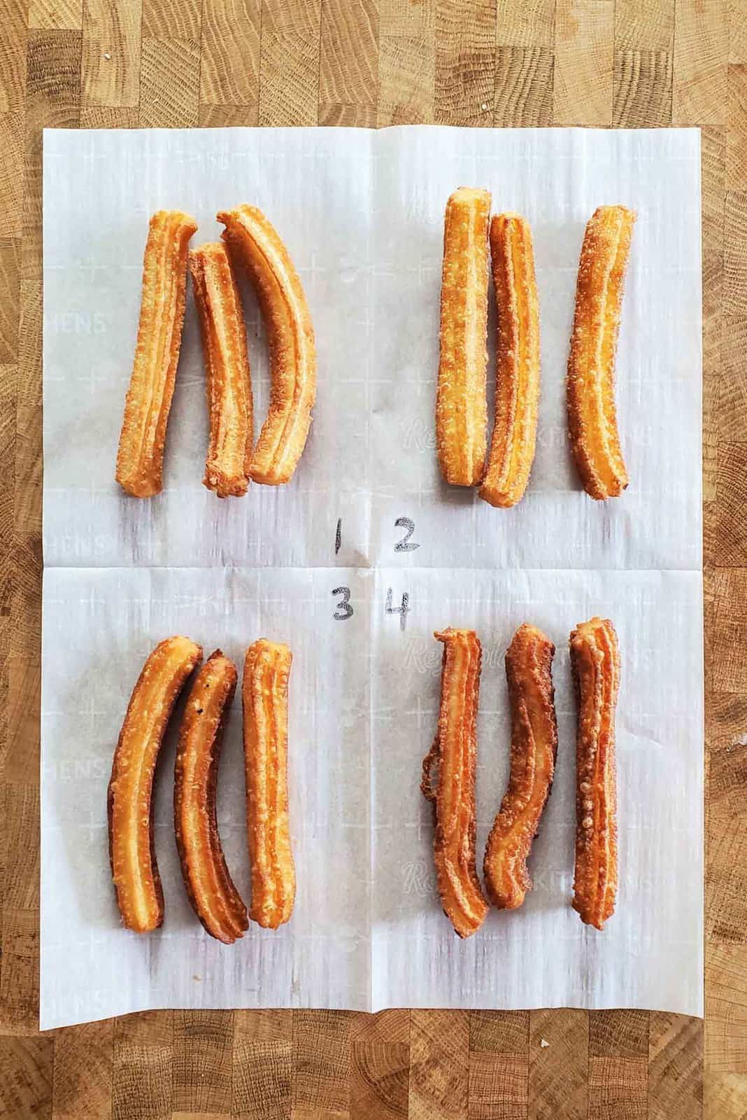 Four different types of churros after frying and placed on a parchment paper with each quadrant numberd from 1 - 4.