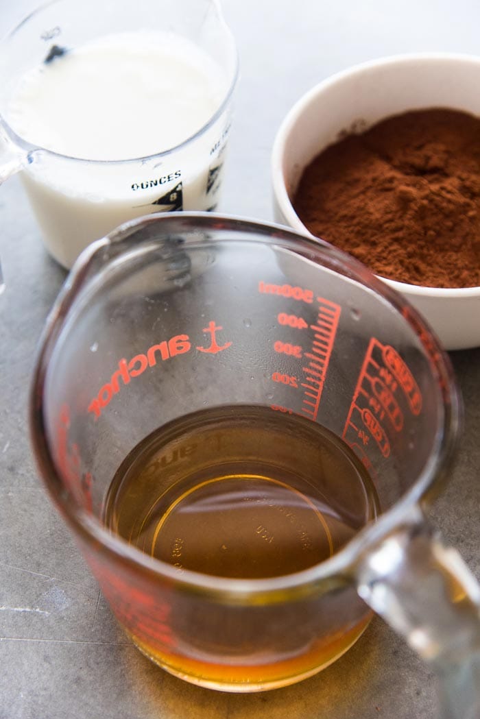 Hot water and vanilla in a jug, with cocoa powder, and buttermilk in separate bowls. 