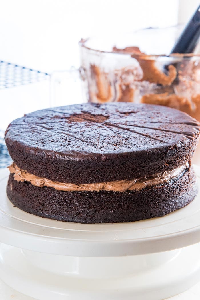 The buttercream has been spread out, and a second chocolate cake layer placed on top.
