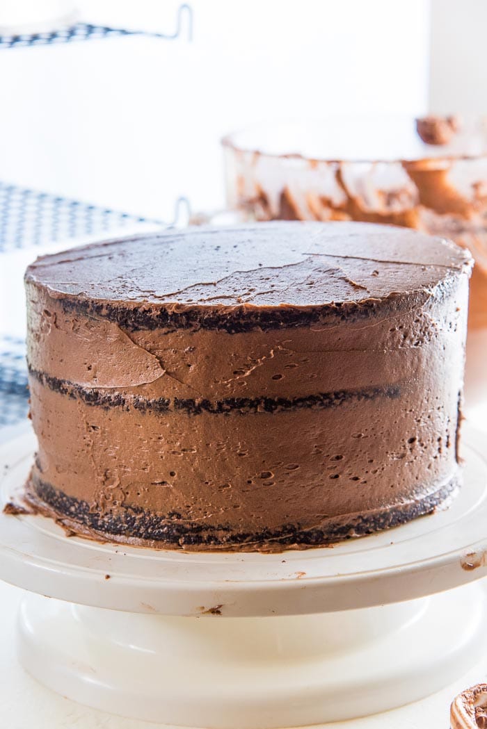 Apply a thin coating of chocolate buttercream as a "crumb coating". Crumb Coating is applied to cake to even out the cake and to stick any loose cake crumbs firmly to the cake.
