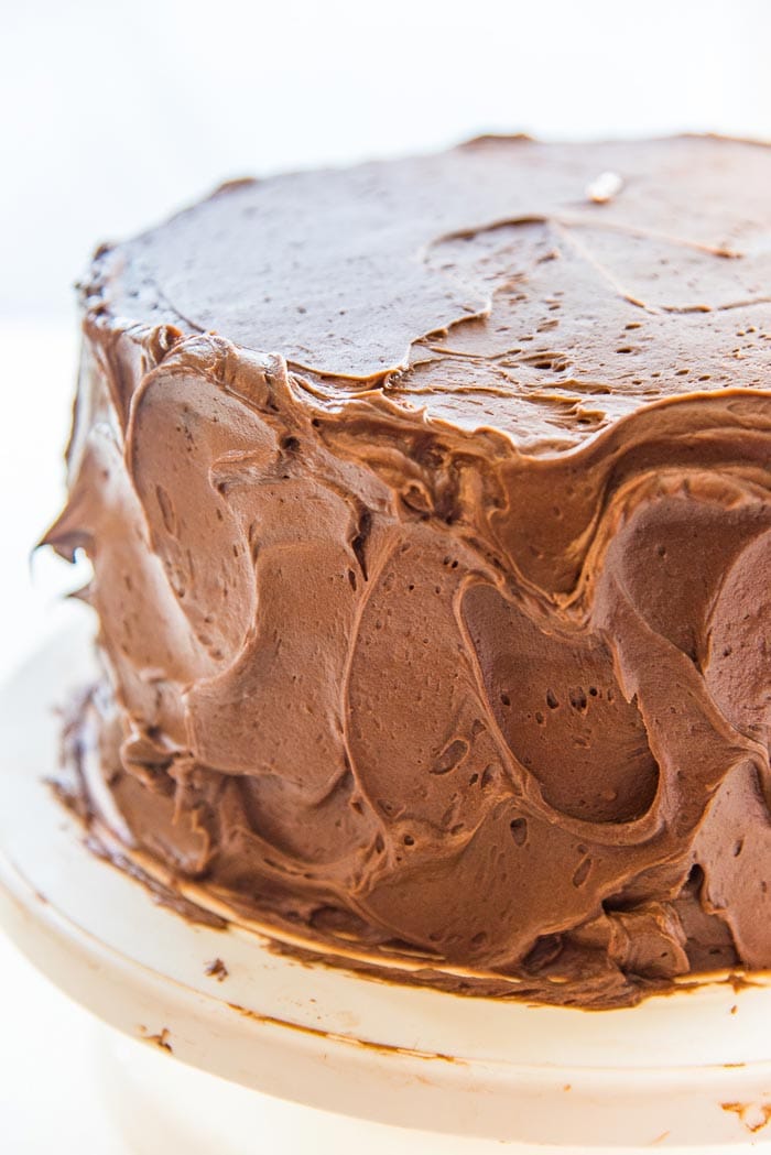 Make swirls of chocolate buttercream using an offset spatula, or the back of a spoon. A close up of the chocolate buttercream swirls on the classic chocolate cake.
