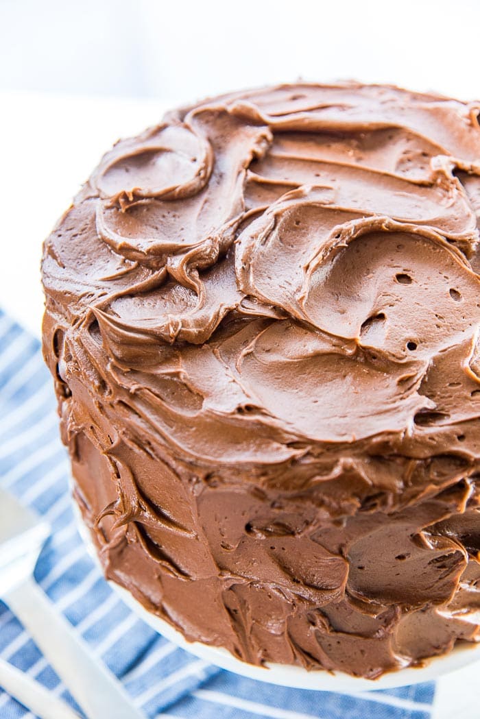 A high angle of the classic chocolate cake, showing the swirled, soft chocolate buttercream. This buttercream is creamy and buttery and easy to spread or pipe on cakes.