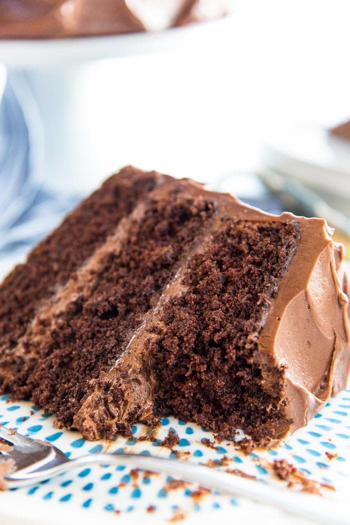 A close up of the Classic Chocolate Layer Cake with creamy chocolate buttercream, and soft, airy chocolate cake layers.