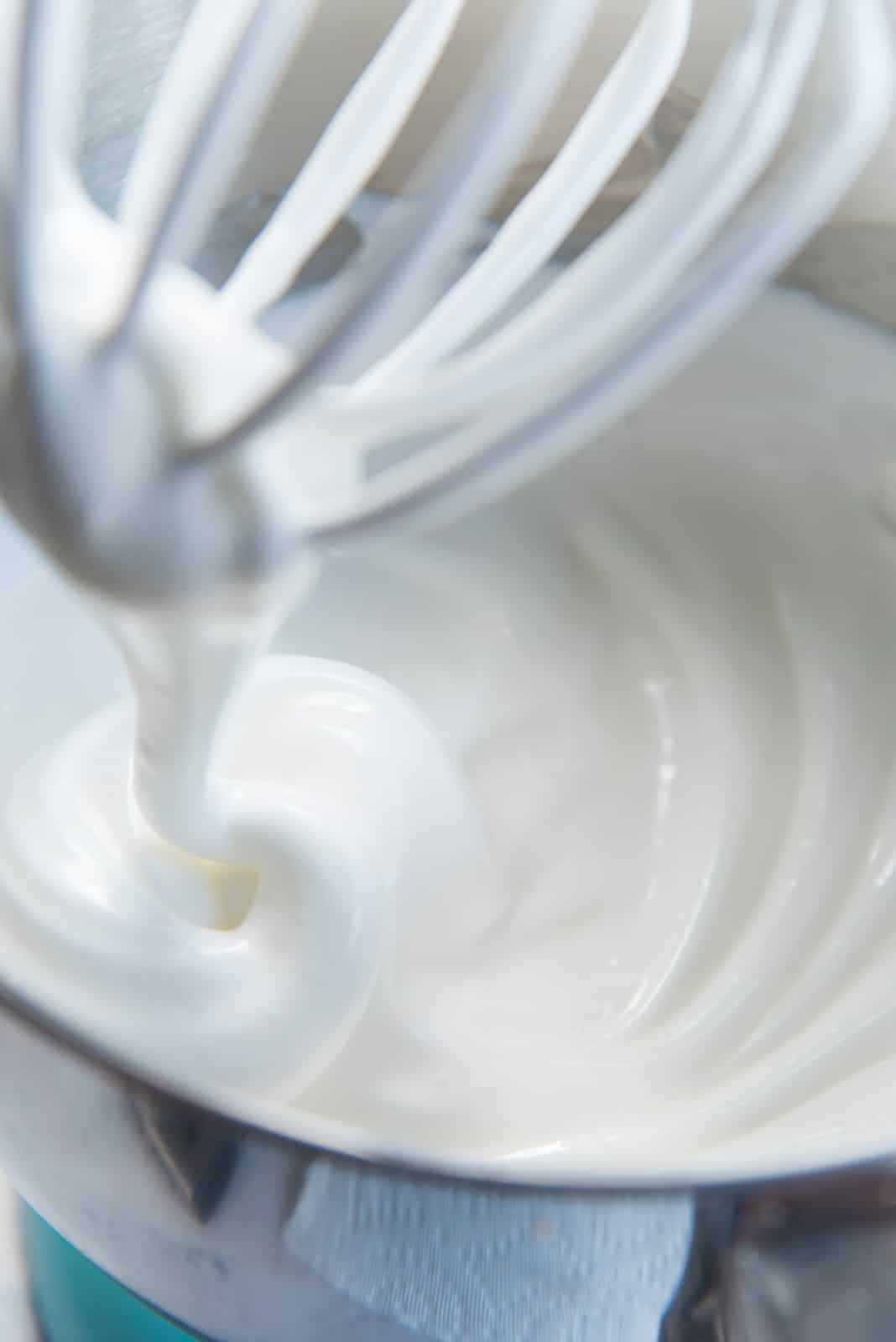 The meringue halfway through whisking, while adding sugar