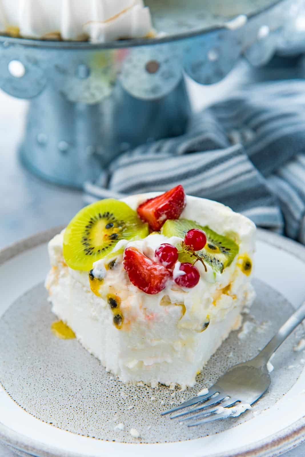 A bite taken out of a slice of pavlova, showing the marshmallow, fluffy center