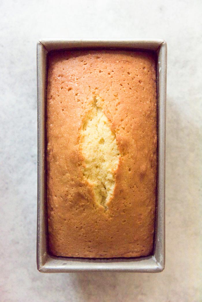 An overhead view of a freshly baked pound cake in the baking pan, while cooling down. 