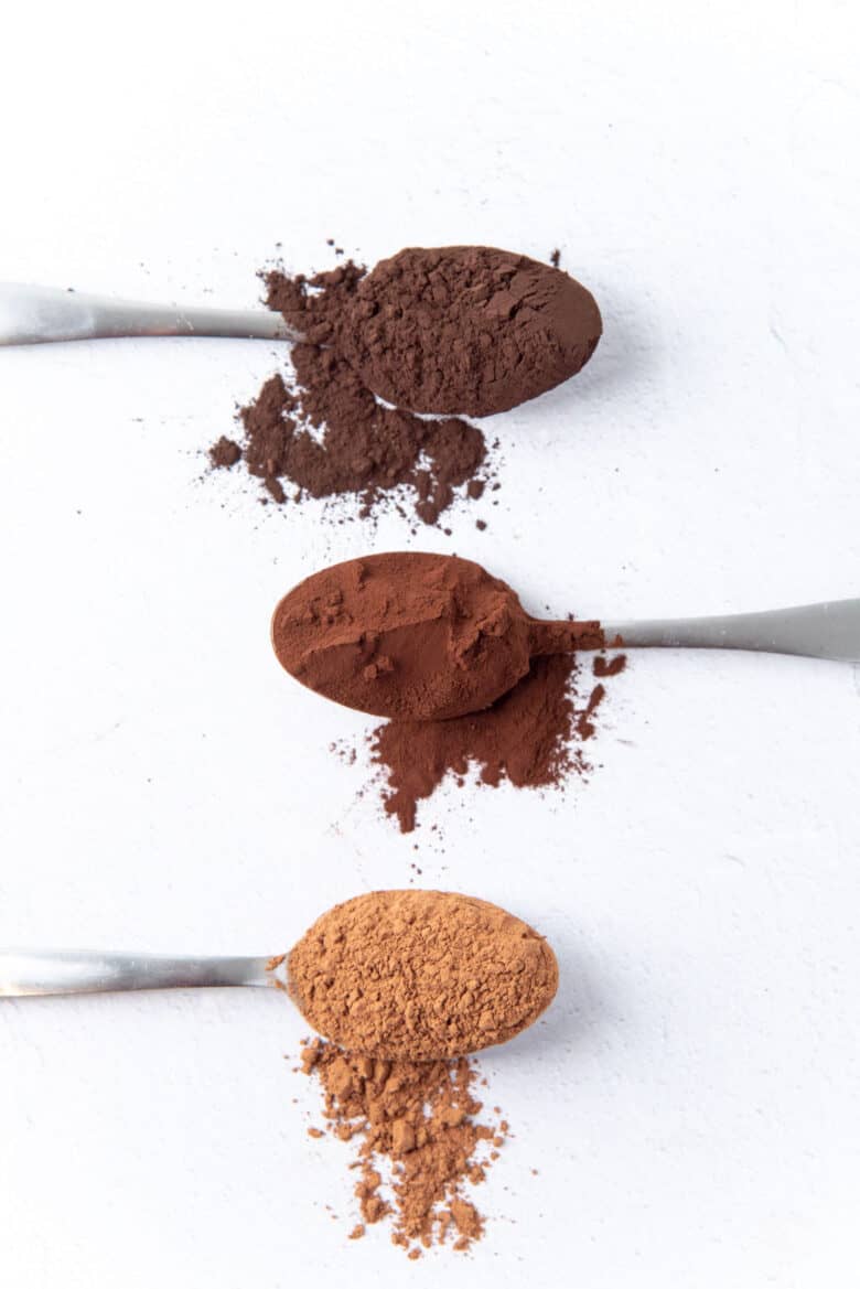 3 spoons of different types of cocoa powder with different colors.