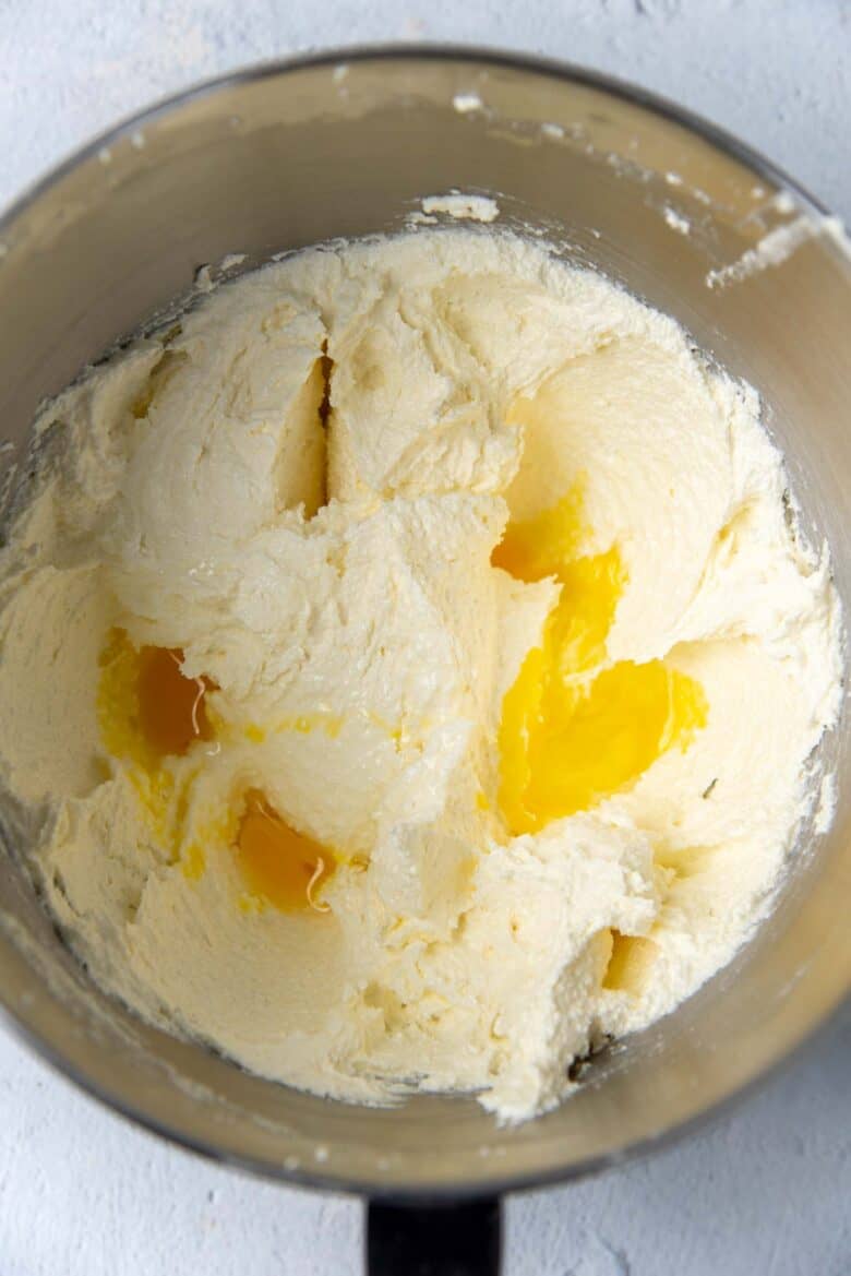 Adding eggs one at a time to the cake batter
