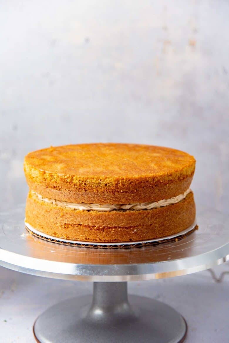 The second coffee flavored cake layer placed on top to assemble the cake