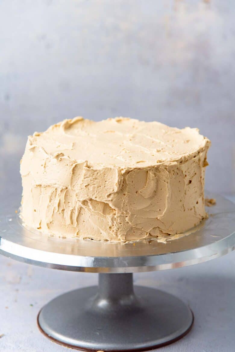 The final layer of coffee buttercream on the cake