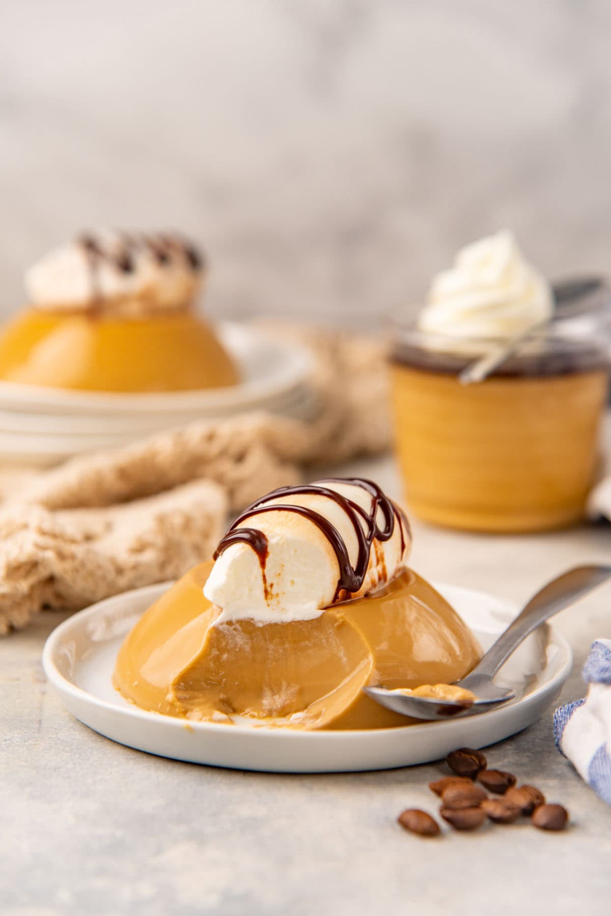 Coffee panna cotta on a plate with a scoop taken out to show creamy texture.