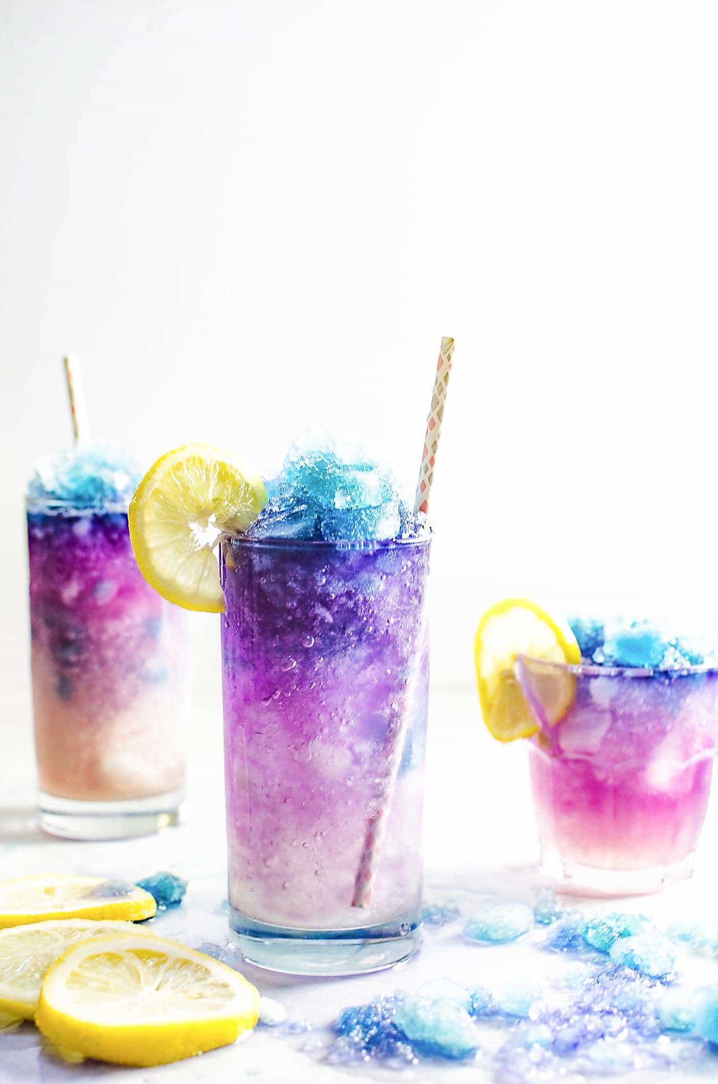 Close up of galaxy lemonade in glasses showing the crushed ice color gradient of pink to purple to blue.
