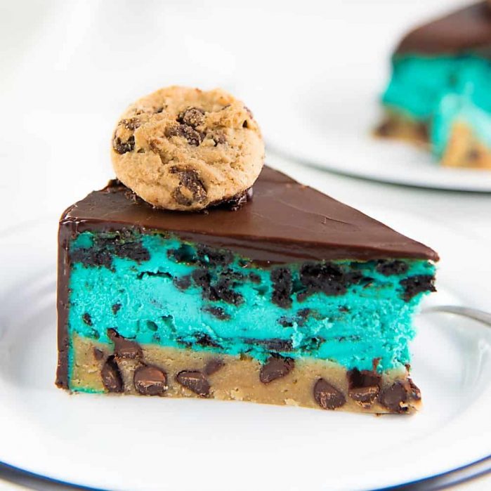 Cookie Monster Cheesecake - A fudgy chewy chocolate chip cookie blondie, topped with a creamy cookie and cream cheesecake loaded with Oreos and coated with a layer of chocolate ganache. Perfect dessert for cookie lovers. From the Secret Layer Cakes cookbook.