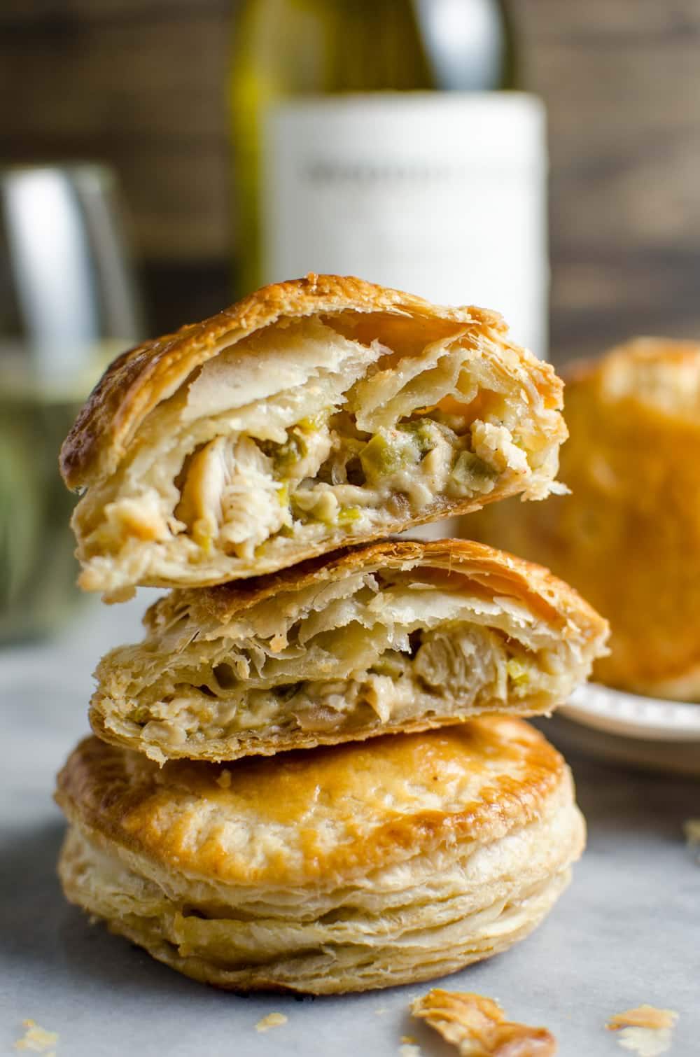 Close up of a mini puff pastry chicken pie cut in half to show the chicken filling in the middle.