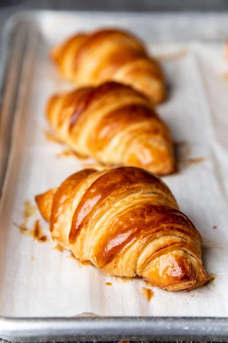 A freshly baked croissant on a baking tray